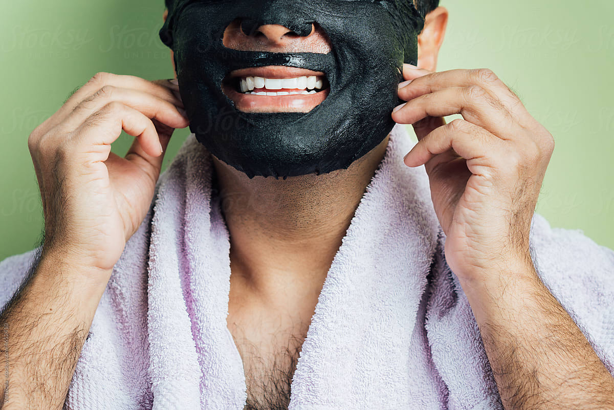 Studio portrait of a happy man wearing black sheet mask